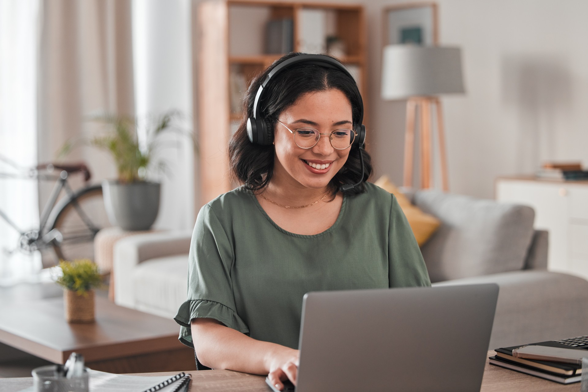 Happy, remote work and woman with a laptop for call center communication and consultation. Smile, virtual assistant and a customer service agent typing on a computer from a house for telemarketing